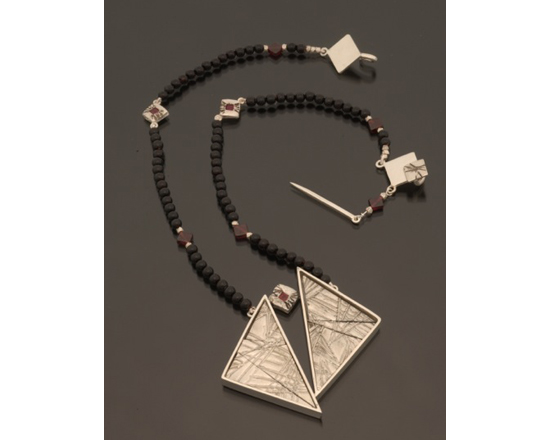 Sterling silver neckpiece with magnetic puzzle pieces and garnet accent
