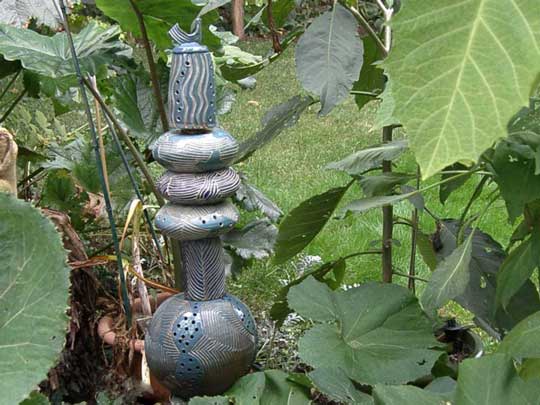 A ceramic sculpture by Naomi Demuth peeking out from the garden