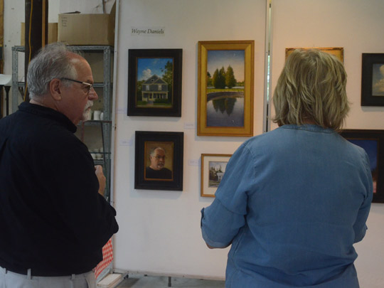 Wayne Daniels with his paintings and an Art Trail follower