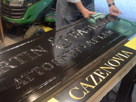 Paul Parpard showing two carved signs in progress