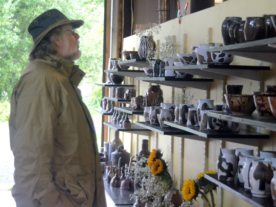 An Art Trail visitor admiring Tim See's ceramic creations